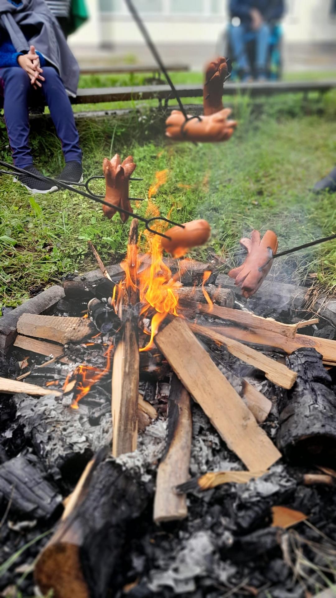 špekáčky opékající se nad ohněm